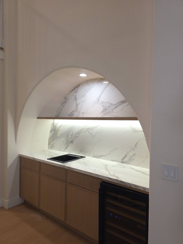 Custom arched niche with marble and built-in cabinetry after remodel Los Angeles