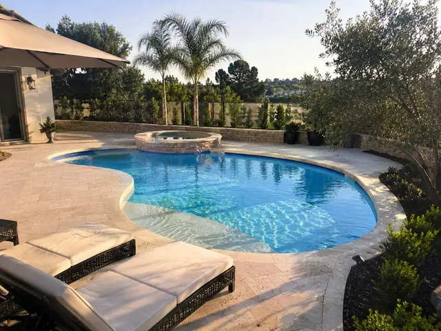 Freeform pool with spa and travertine decking Los Angeles